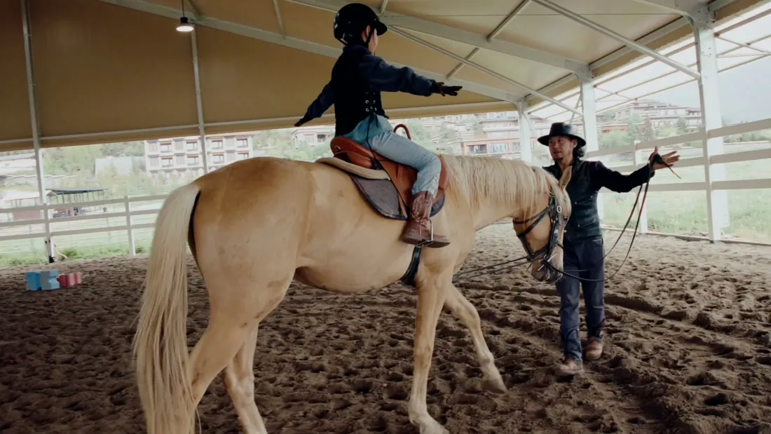 A young rider in a lesson on a palomino